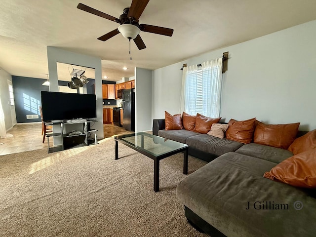 living area featuring light colored carpet and ceiling fan