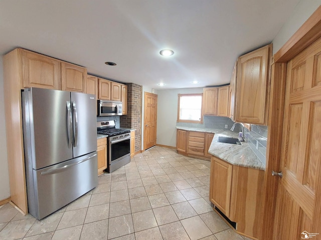 kitchen featuring a sink, backsplash, light brown cabinetry, and stainless steel appliances