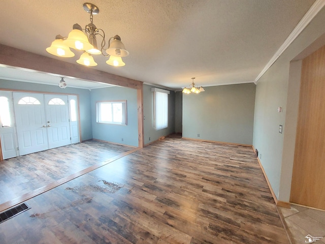 foyer featuring visible vents, wood finished floors, a chandelier, and crown molding