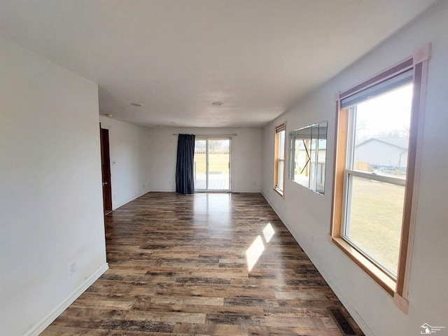 spare room featuring visible vents, baseboards, and wood finished floors