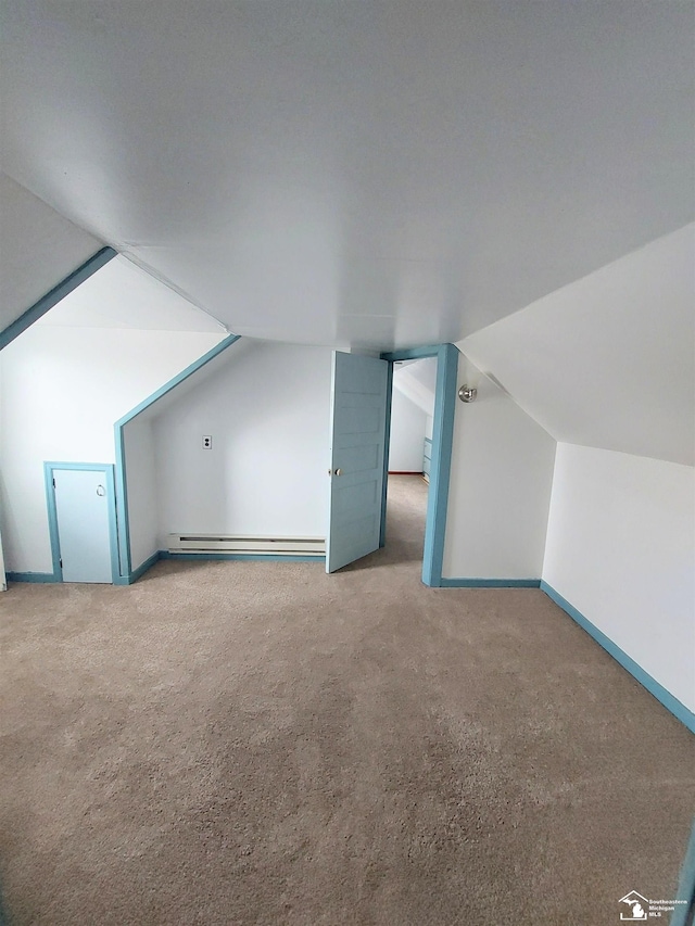 additional living space with baseboards, a baseboard heating unit, lofted ceiling, and carpet floors