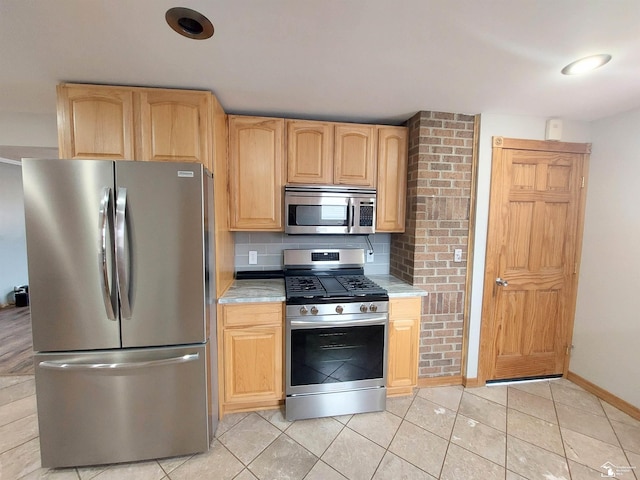 kitchen with backsplash, light brown cabinets, light countertops, light tile patterned flooring, and stainless steel appliances