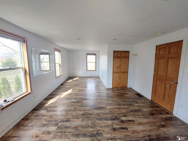 empty room with dark wood-type flooring and baseboards