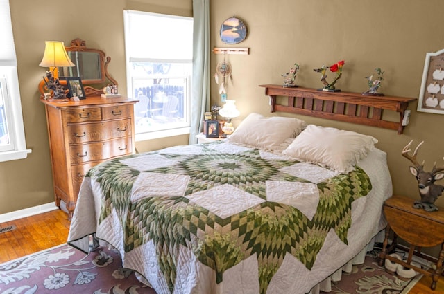 bedroom featuring visible vents, wood finished floors, and baseboards