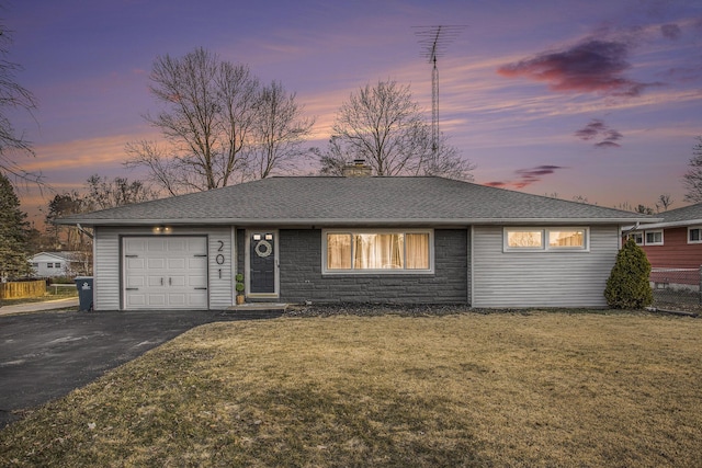 ranch-style house featuring a front yard, a chimney, a garage, stone siding, and driveway