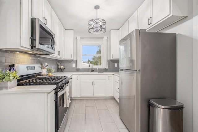 kitchen featuring a sink, decorative backsplash, light countertops, appliances with stainless steel finishes, and white cabinetry