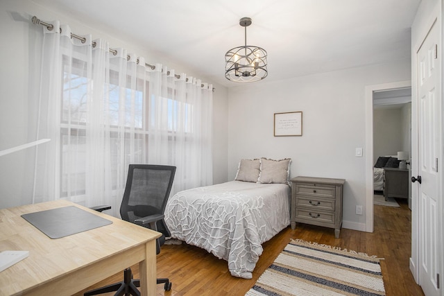 bedroom with a chandelier and wood finished floors