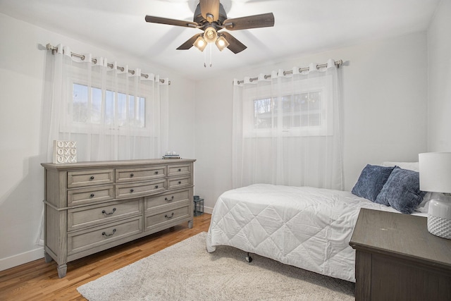 bedroom featuring light wood-style floors, baseboards, and ceiling fan