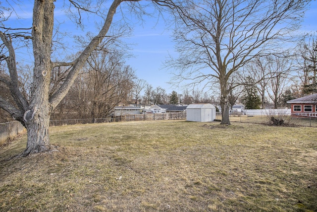 view of yard featuring an outbuilding, a fenced backyard, and a shed