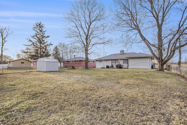 view of yard with a fenced backyard, a storage shed, and an outdoor structure