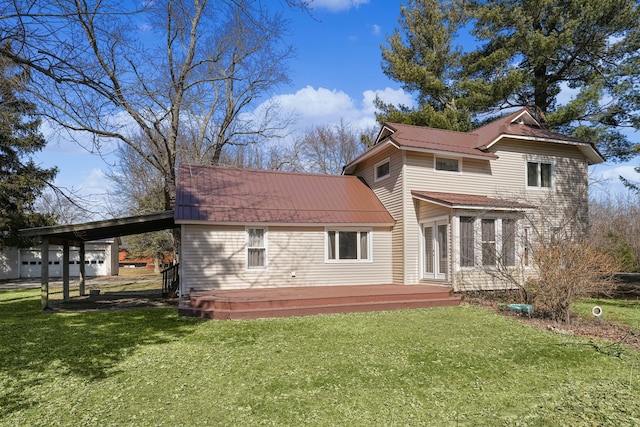 rear view of property with metal roof, an attached carport, a yard, and a wooden deck