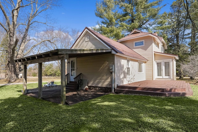 back of property with entry steps, a carport, french doors, a deck, and a lawn