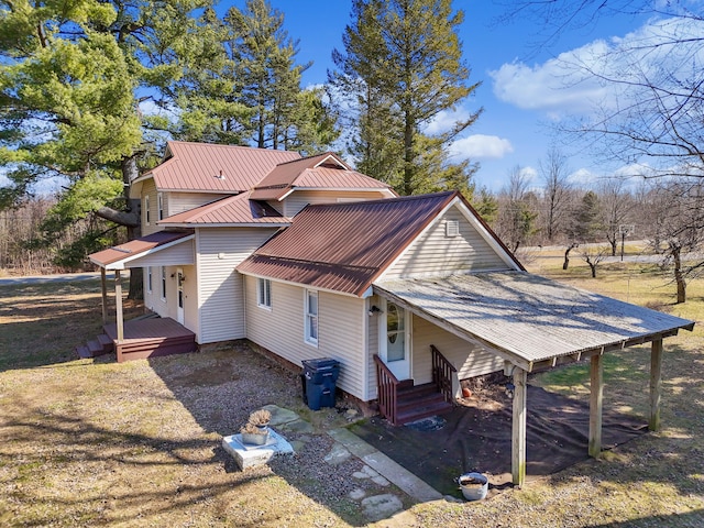 view of side of property featuring metal roof and covered porch