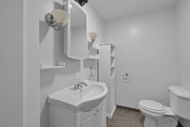 bathroom featuring vanity, toilet, baseboards, and tile patterned flooring