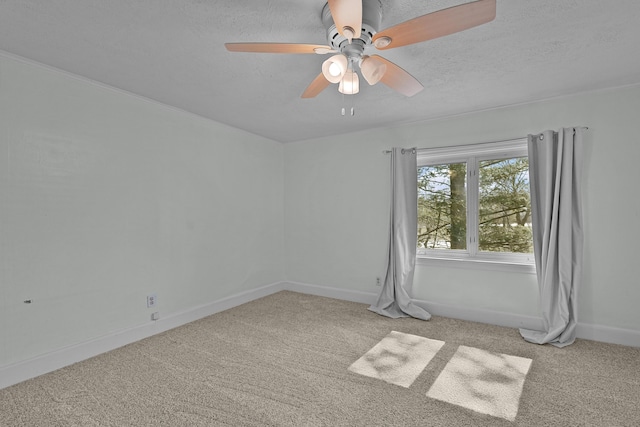 carpeted spare room featuring ceiling fan, baseboards, and a textured ceiling