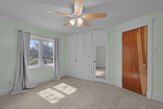 unfurnished bedroom featuring baseboards, a textured ceiling, ceiling fan, and carpet floors