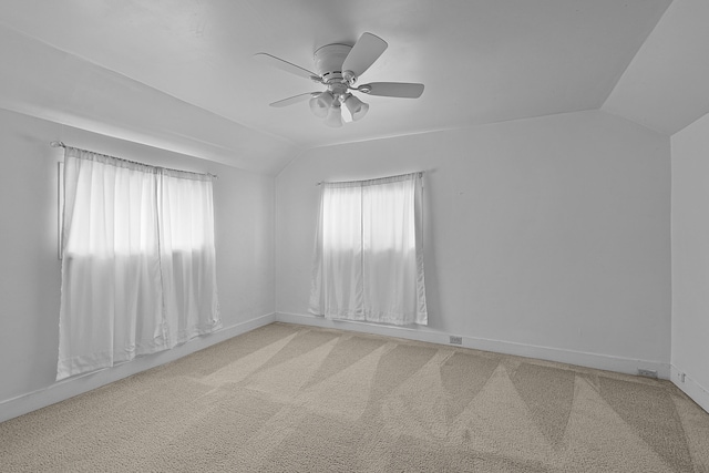 carpeted empty room with baseboards, lofted ceiling, and ceiling fan