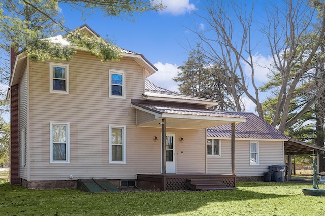 rear view of property featuring metal roof, a yard, and a carport