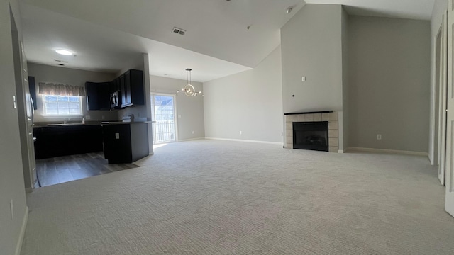 unfurnished living room featuring visible vents, baseboards, carpet flooring, and a tile fireplace