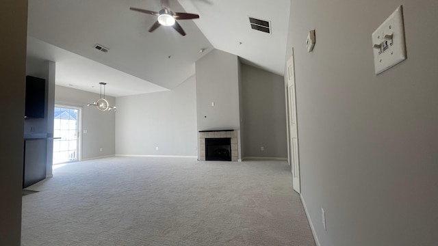 unfurnished living room featuring visible vents, light colored carpet, a tiled fireplace, and ceiling fan with notable chandelier