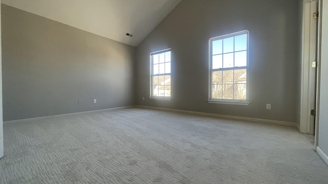 unfurnished room featuring baseboards, light carpet, high vaulted ceiling, and visible vents