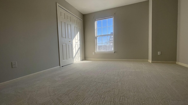 unfurnished bedroom featuring a closet, baseboards, and light carpet