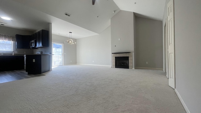 unfurnished living room featuring a wealth of natural light, visible vents, light carpet, and baseboards