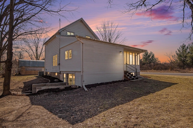 view of side of property with entry steps and central AC unit