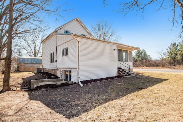 view of side of home featuring central AC unit and entry steps