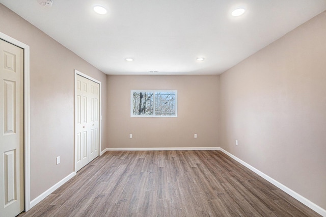 unfurnished bedroom with recessed lighting, baseboards, and wood finished floors