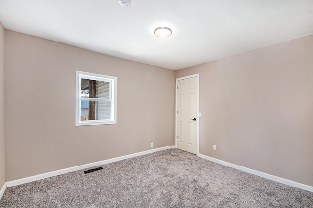 spare room featuring visible vents, carpet, and baseboards