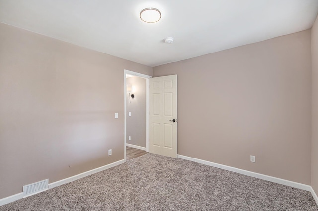 carpeted empty room with visible vents and baseboards