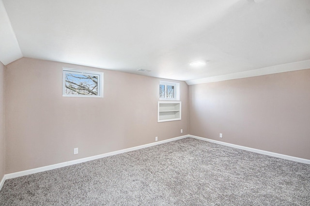 basement featuring visible vents, baseboards, and carpet floors