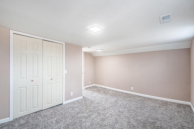 unfurnished bedroom with a closet, visible vents, baseboards, and carpet