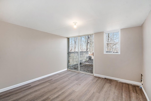 empty room with baseboards and wood finished floors