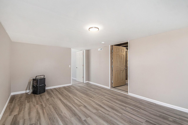 empty room with visible vents, wood finished floors, and baseboards