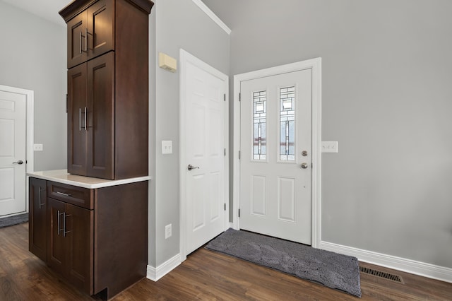 foyer featuring visible vents, baseboards, and dark wood-style floors