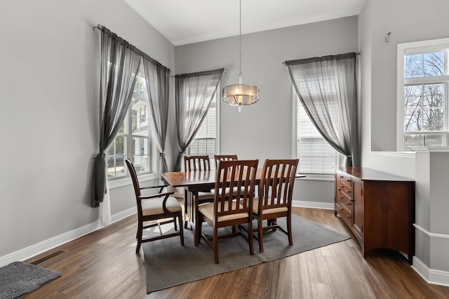 dining room featuring an inviting chandelier, visible vents, dark wood-style floors, and baseboards