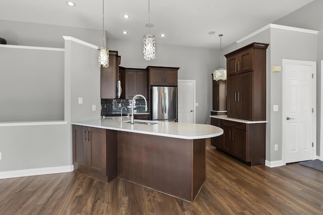 kitchen featuring a sink, dark brown cabinetry, a peninsula, and freestanding refrigerator