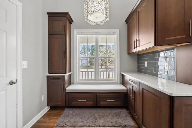 interior space with baseboards, dark wood-type flooring, and an inviting chandelier