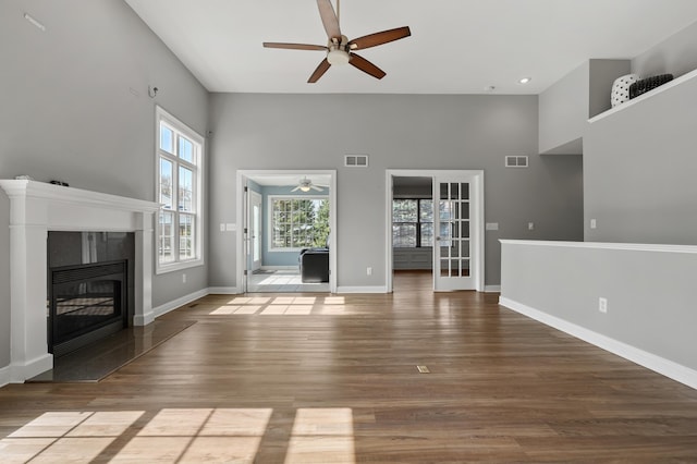 unfurnished living room with visible vents, baseboards, ceiling fan, and wood finished floors