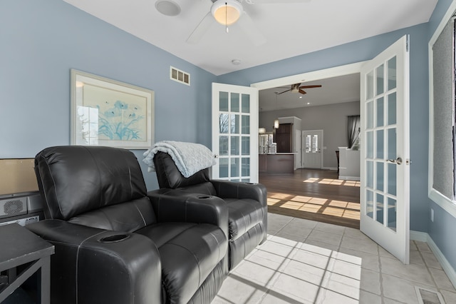 living room with light tile patterned flooring, visible vents, french doors, and a ceiling fan