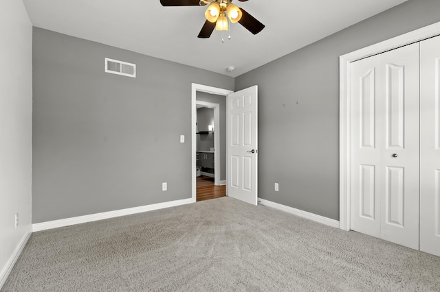 unfurnished bedroom with a closet, baseboards, visible vents, and carpet floors