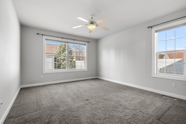 carpeted empty room featuring visible vents, baseboards, and ceiling fan