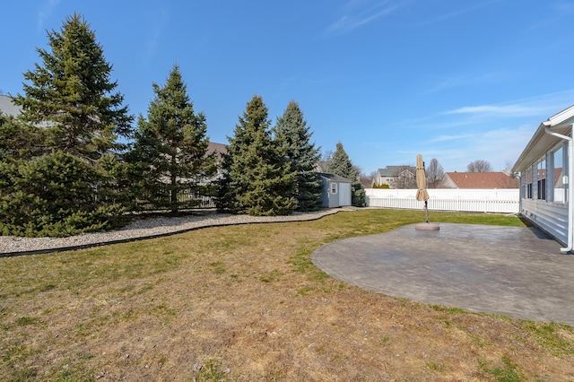 view of yard featuring an outdoor structure, a storage unit, a fenced backyard, and a patio