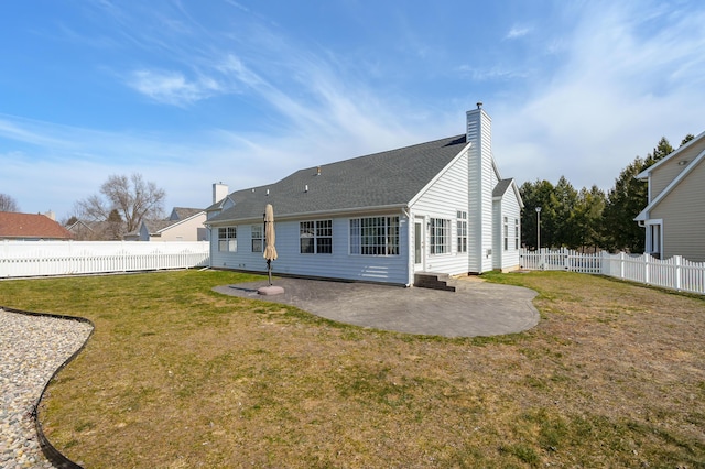 rear view of property with entry steps, a patio, a fenced backyard, a yard, and a chimney