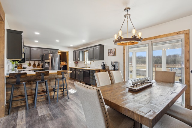 dining area featuring recessed lighting, dark wood-type flooring, and a notable chandelier