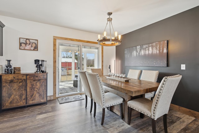 dining room with baseboards, an inviting chandelier, and wood finished floors