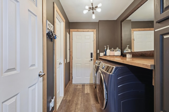 laundry area with wood finished floors, a notable chandelier, separate washer and dryer, and laundry area