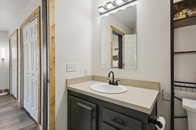 bathroom featuring toilet, wood finished floors, and vanity